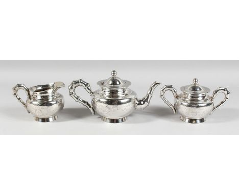 A CHINESE SILVER TEA SET engraved with birds with bamboo pattern handles and spout, comprising TEAPOT, sugar basin and milk j