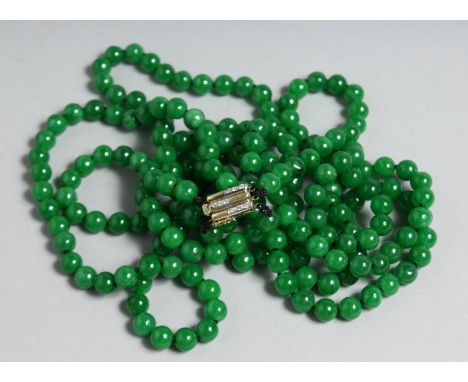 A SUPERB JADE TRIPLE ROW NECKLACE with gold and diamond clasp.