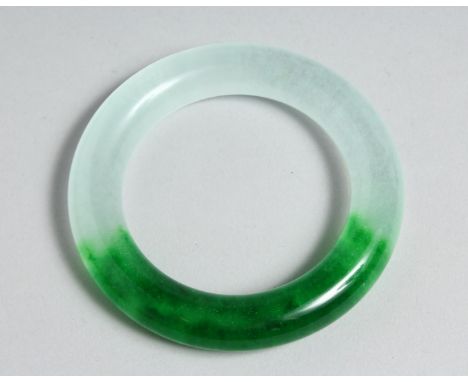 A TWO TONE JADE BANGLE. 3.25ins diameter.