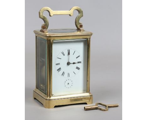 A 19th century French brass cased 8 day carriage alarm clock striking on a gong. With enamel dial having Roman numeral marker