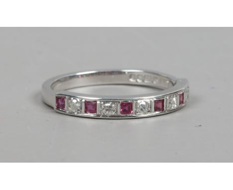 A modern 18 carat white gold ruby and diamond channel set half eternity ring. Size N.   Condition Report. To be used as a gui