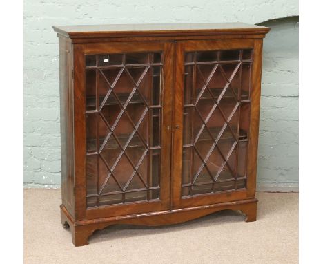 An inlaid mahogany astrigal glazed bookcase raised on bracket feet.