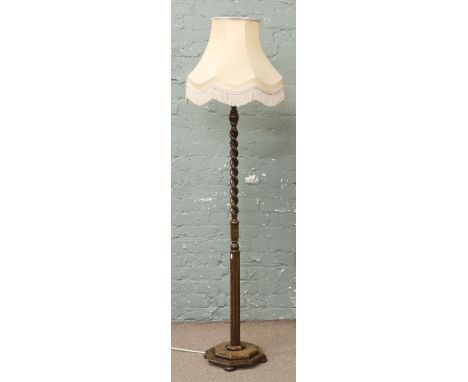 A 1940s oak barleytwist standard lamp raised on a stepped octagonal plinth.
