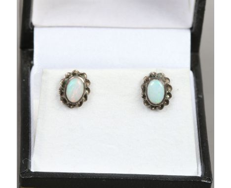 A pair of opal set silver ear studs.