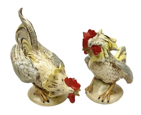 Pair of ceramic fighting Cockerels, with stamped and impressed marks beneath, tallest 20cm