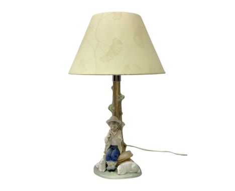 Nao table lamp modelled as a boy playing the flute upon logs with two recumbent sheep at his feet, the stem modelled as a tre