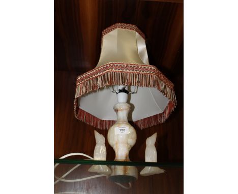 AN ONYX LAMP TOGETHER WITH A PAIR OF ONYX PENGUINS 