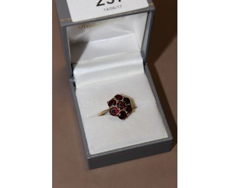 A LADIES 9CT GOLD FLORAL SET GARNET DRESS RING 