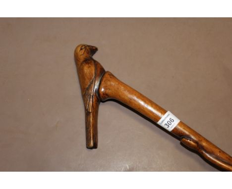 A FOLK ART WALKING STICK WITH HANDLE IN THE FORM OF A PERCHED BIRD,  the cane being carved with a serpent ascending the stick