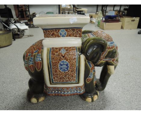 A large ceramic elephant plant stand with an Eastern style 
