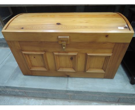 A modern pine dome topped bedding trunk