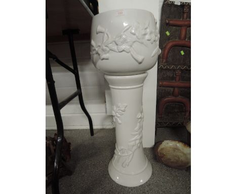 A ceramic jardiniere with foliate work to base and vase