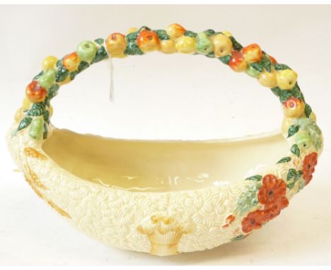 A CLARICE CLIFF (Newport Pottery) CELTIC HARVEST BOAT SHAPE BASKET with polychromed fruit  moulded overhead handle, 13" (32.5