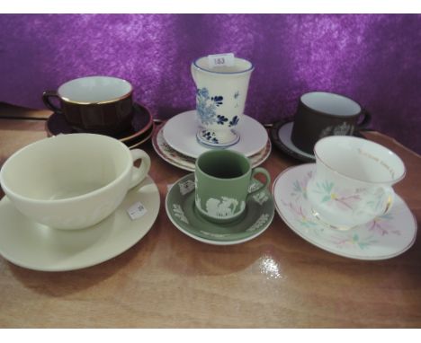 A selection of vintage tea cups and saucers including delft ware