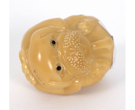 A vegetable ivory carved netsuke, modelled as a dog with beaded eyes, 4cm high