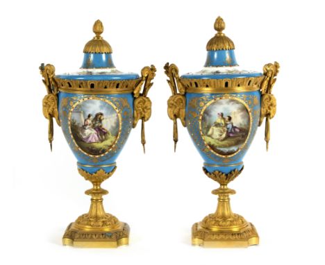 A pair of Sèvres style porcelain urns and covers, each decorated figural and floral reserves to a bleu céleste ground, with g