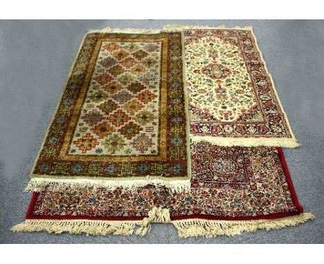 A modern Tabris carpet worked in reds, yellows and blues to a cream ground, 200cm x 140cm and two others