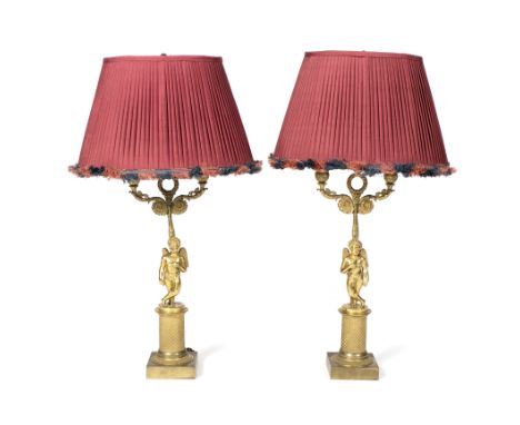 A pair of Louis XVI style ormolu table lamps with cherub bases on plinths, 66cm high (including lamp shade)/see illustration