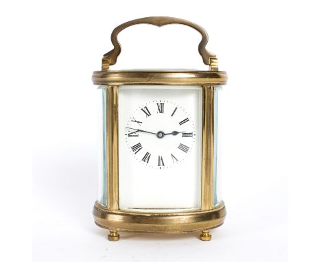 An oval gilt brass cased carriage clock, the rectangular white enamel dial with Roman numerals, 15cm high handle up