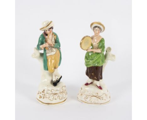 A pair of 19th Century Staffordshire porcelaneous figures of musicians, she holding a tambourine, he playing a pipe, 20cm hig