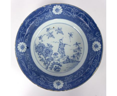 An English Delftware bowl, mid 18th Century, Lambeth High Street, decorated a Chinaman in a garden within a powder blue borde