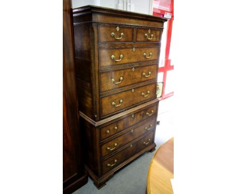 An oak cabinet with false two-drawer and three-drawer front above three long drawers on ogee bracket feet (in the style of a 