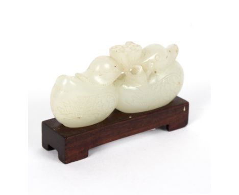 A Chinese jade carving of two mandarin ducks and a lotus flower, on a hardwood stand, 6cm wide