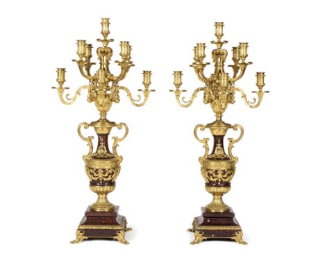 A pair of 19th Century gilt metal nine-light candelabra, having two-tiers of four scroll branches linked by swags, raised on 