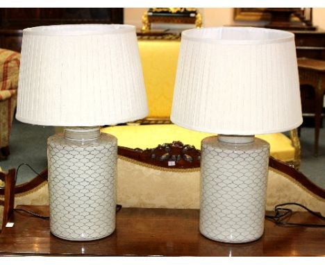 A pair of modern ceramic table lamps, each with geometric decoration to a cream ground, 65cm high including shade