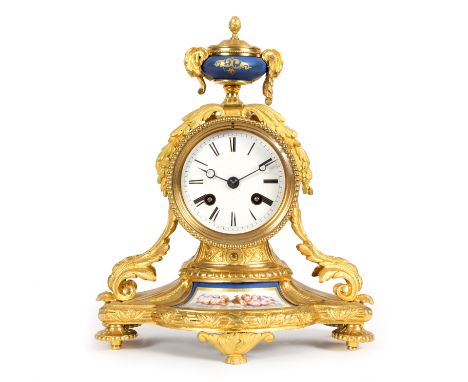 A 19th Century French mantel clock with porcelain mounted urn finial, acanthus clad sides and porcelain mounted base on circu