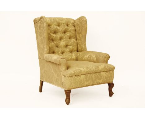 A George III style gold upholstered button back wing armchair, on short cabriole legs, 85 x 104 x 80cm