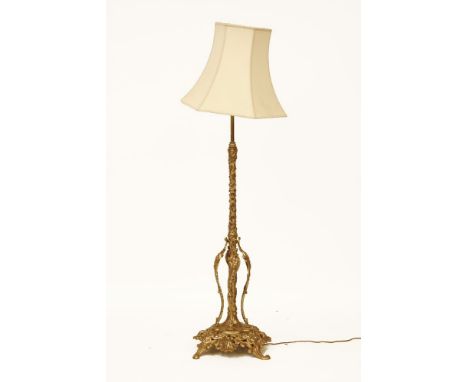 A Victorian ornate brass standard lamp, with an extending central column, with a shaped shade