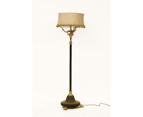 A modern brass and black metal standard lamp and shade
