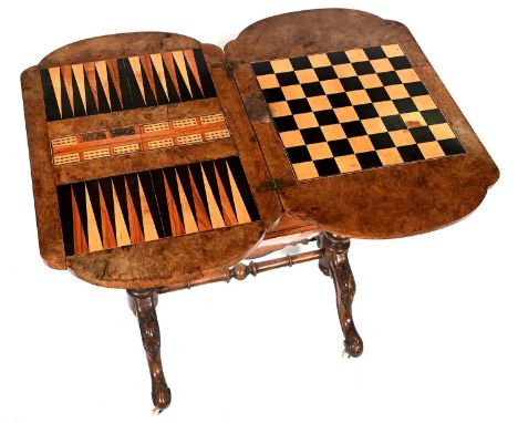 A Victorian bow ended walnut and inlaid work table, the quarter veneered fold over top inlaid for games and fitted with a dra