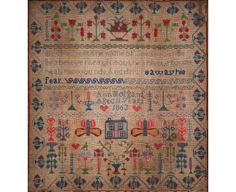 A Victorian wool sampler, Ann Morgans aged 11 years 1863, worked with house, butterflies, trees and flowers around a verse, 6