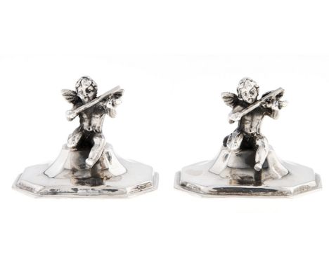 A pair of silver Putto musician novelty place stands, 20th c, on flared octagonal base, 30mm h, marked STERLING, loaded  Ligh