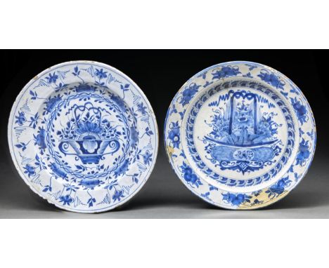 Two English Delftware dishes, c1770, painted with a central flower filled basket bordered by stylised flowers, 34 and 36cm di