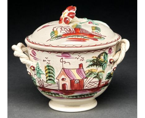 An English creamware sucrier and cover, c1780-90, with entwined handles and flower knop, brightly painted with a hut and fenc