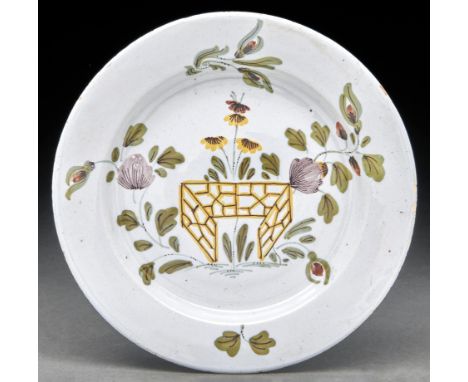A Liverpool Delftware plate, c1760, painted in the Fazackerley palette with flowers and fence, 22cm diam  In unusually well p