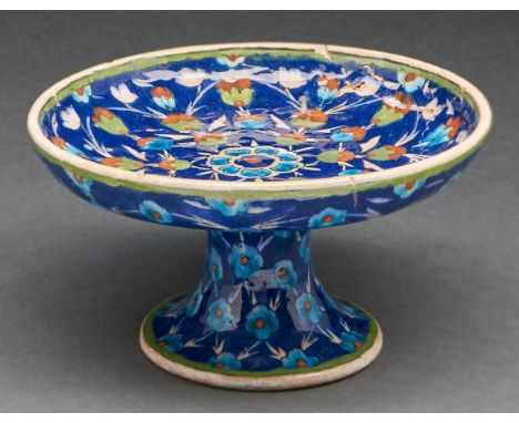 An Armenian pottery tazza, Palestine, first half 20th c, painted with stylised flowers in green, turquoise and red on a blue 