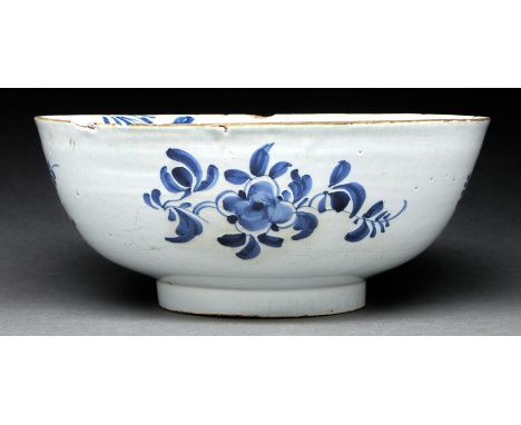 An English Delftware bowl, Lambeth, c1760-70, painted with flowers and trailing foliage, 26.5cm diam  Chipped and flaking aro