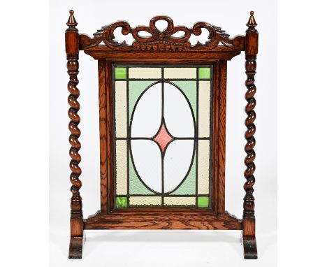 A carved oak and leaded glass firescreen, early 20th c, with spiral uprights, 68cm h  Good condition