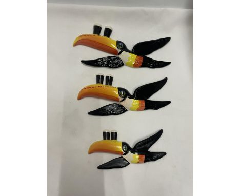 A SET OF THREE GRADUATED CARLTON WARE GUINNESS TOUCANS IN FLIGHT WALL HANGING DECORATIONS 