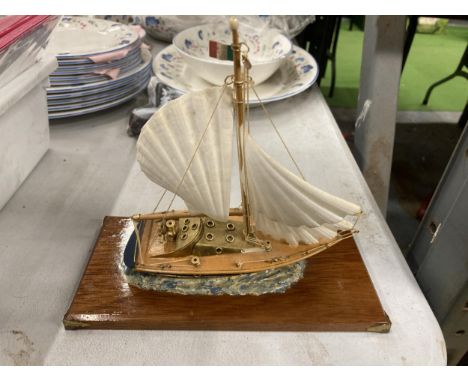 A MODEL OF A VINTAGE ITALIAN YACHT, ON A WOODEN PLINTH, WITH ENAMEL AND BRASS HULL, HEIGHT APPROX 18CM, LENGTH 20CM 