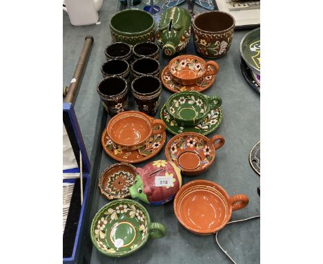 A COLLECTION OF POTTERY DECORATED IN A 'BARGE ART' STYLE TO INCLUDE A PIGGY BANK, PLANTERS, CUPS, SAUCERS, ETC 