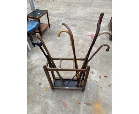 A MID 20TH CENTURY OAK THREE DIVISION STICK STAND AND QUANTITY OF WALKING STICKS 