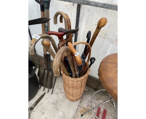 A WICKER STICK STAND AND AN ASSORTMENT OF WALKING STICKS 