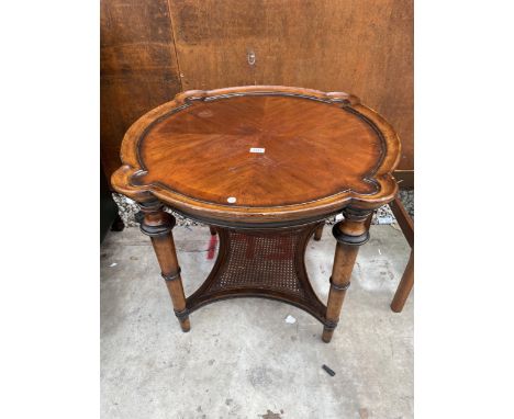 AN FBIS FURNITURE HARDWOOD TWO TIER OCCASIONAL TABLE WITH SHAPED TOP AND CANE LOWER SHELF ON TURNED LEGS, 34" DIAMETER 