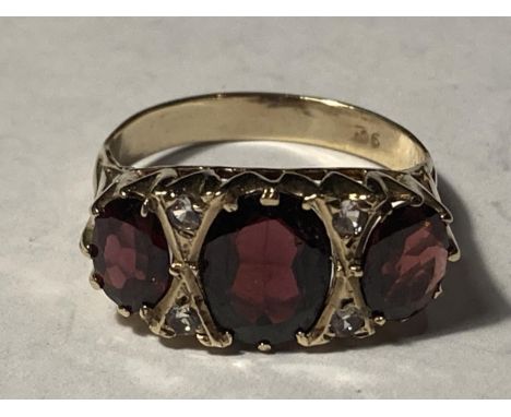 A 9 CARAT GOLD RING WITH THREE LARGE GARNETS SUUROUNDED BY CUBIC ZIRCONIAS SIZE R 