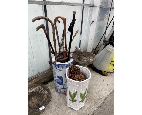 TWO CERAMIC STICK STANDS AND AN ASSORTMENT OF WALKING STICKS 